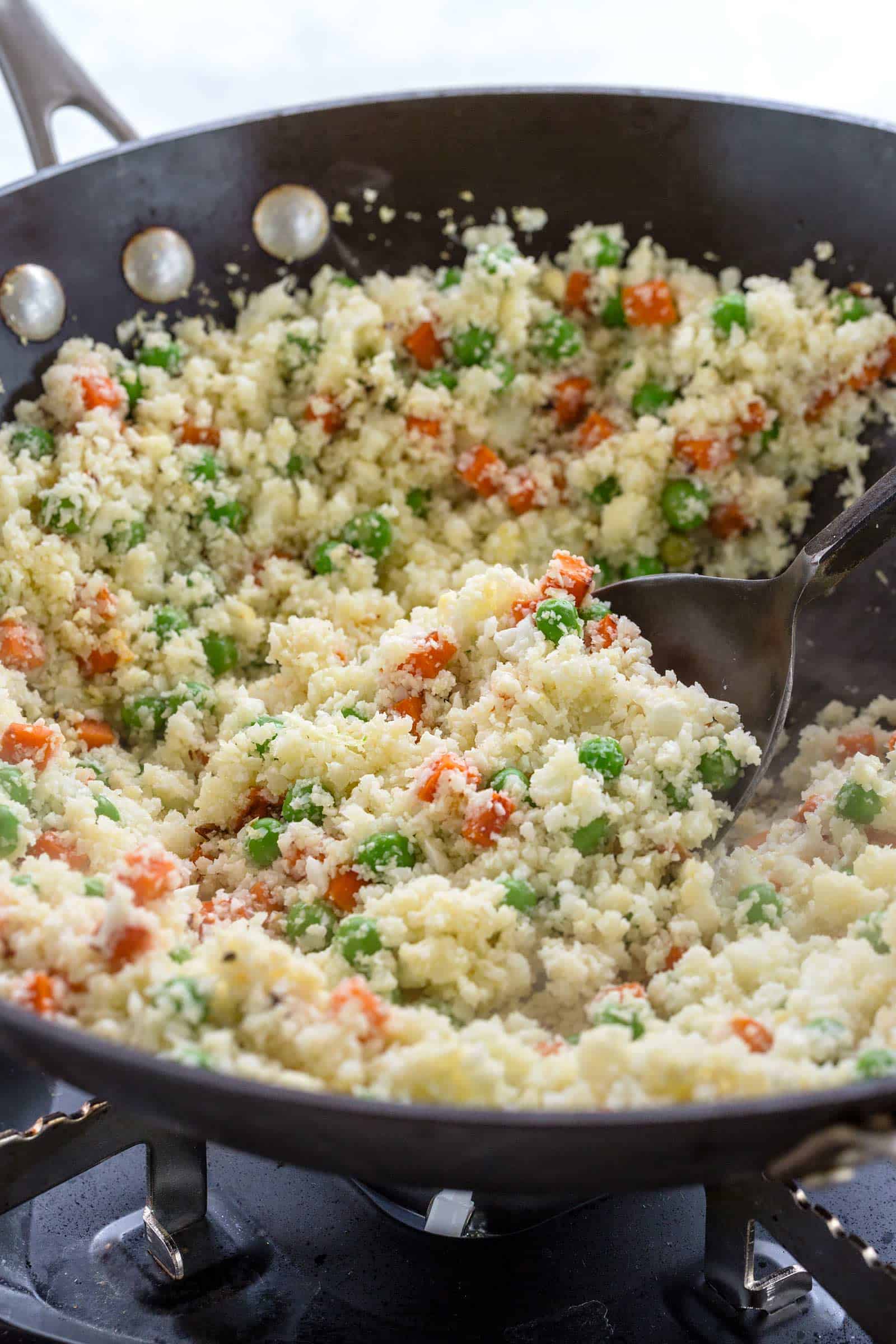 making cauliflower fried rice in a wok