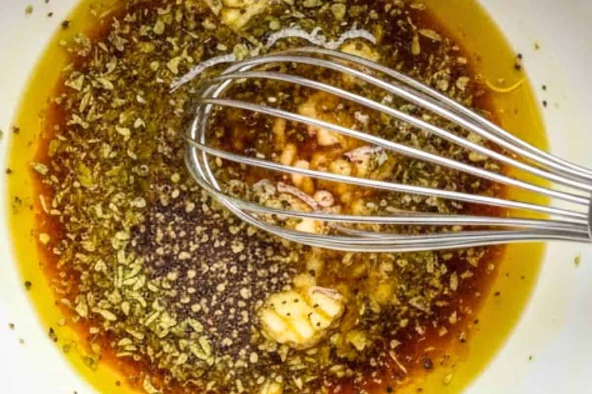 In a medium bowl, whisk together the olive oil, red wine vinegar, garlic, oregano, salt and pepper  - 3