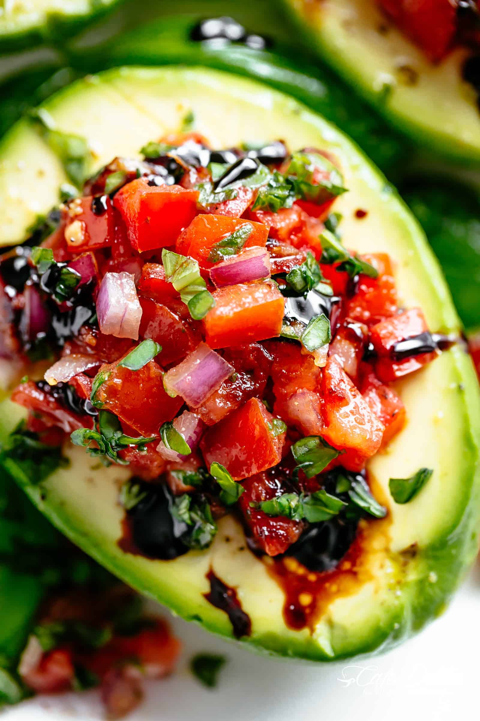 Take creamy avocados to a different level with Bruschetta Stuffed Avocados! Bruschetta tomato stuffed into Avocados with parmesan and a balsamic reduction! | cafedelites.com