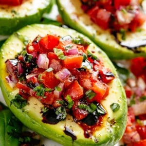 Bruschetta tomato stuffed into Avocados with parmesan and a balsamic reduction
