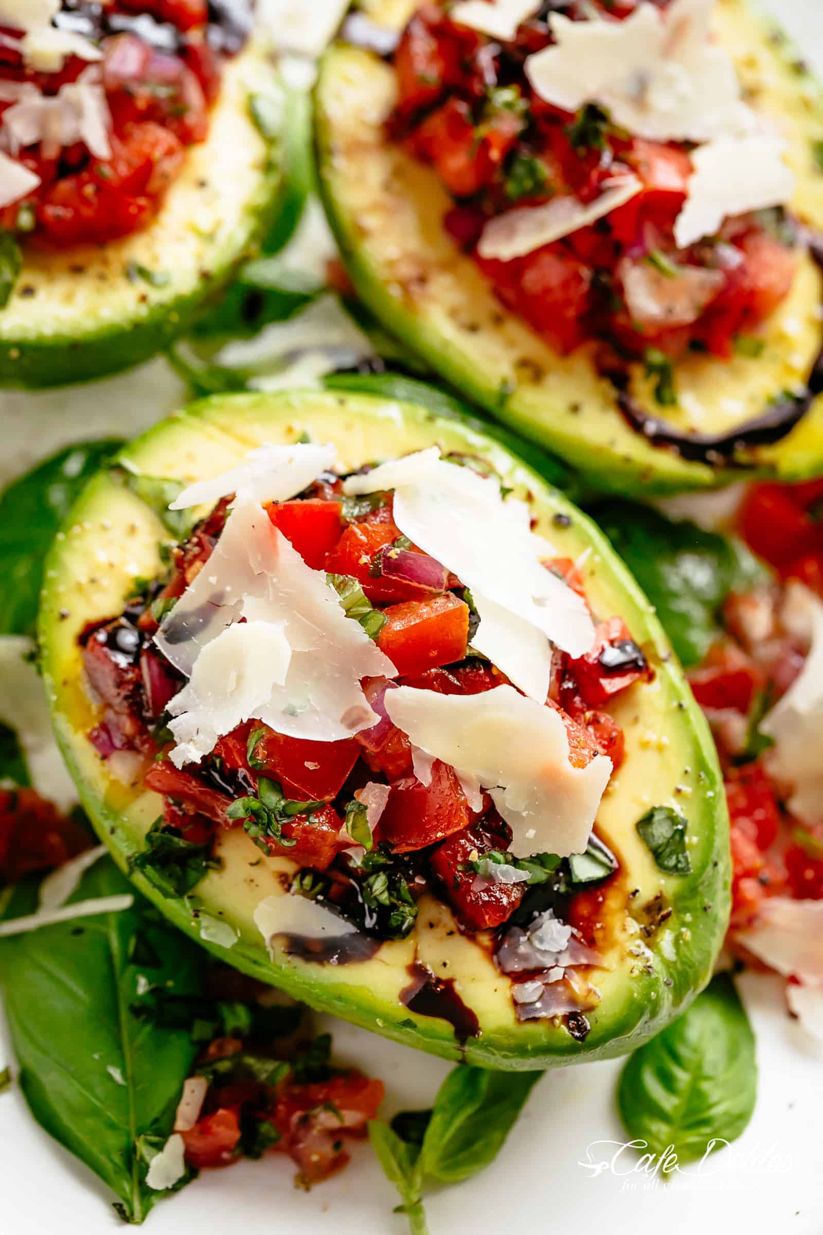 Take creamy avocados to a different level with Bruschetta Stuffed Avocados! Bruschetta tomato stuffed into Avocados with parmesan and a balsamic reduction! | cafedelites.com