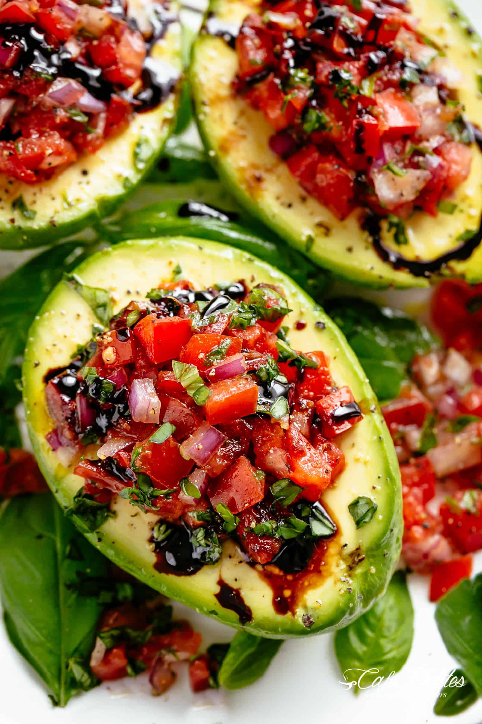 Take creamy avocados to a different level with Bruschetta Stuffed Avocados! Bruschetta tomato stuffed into Avocados with parmesan and a balsamic reduction! | cafedelites.com