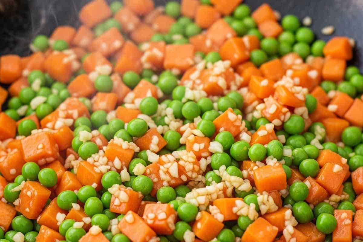 Carrots and peas added to the wok.