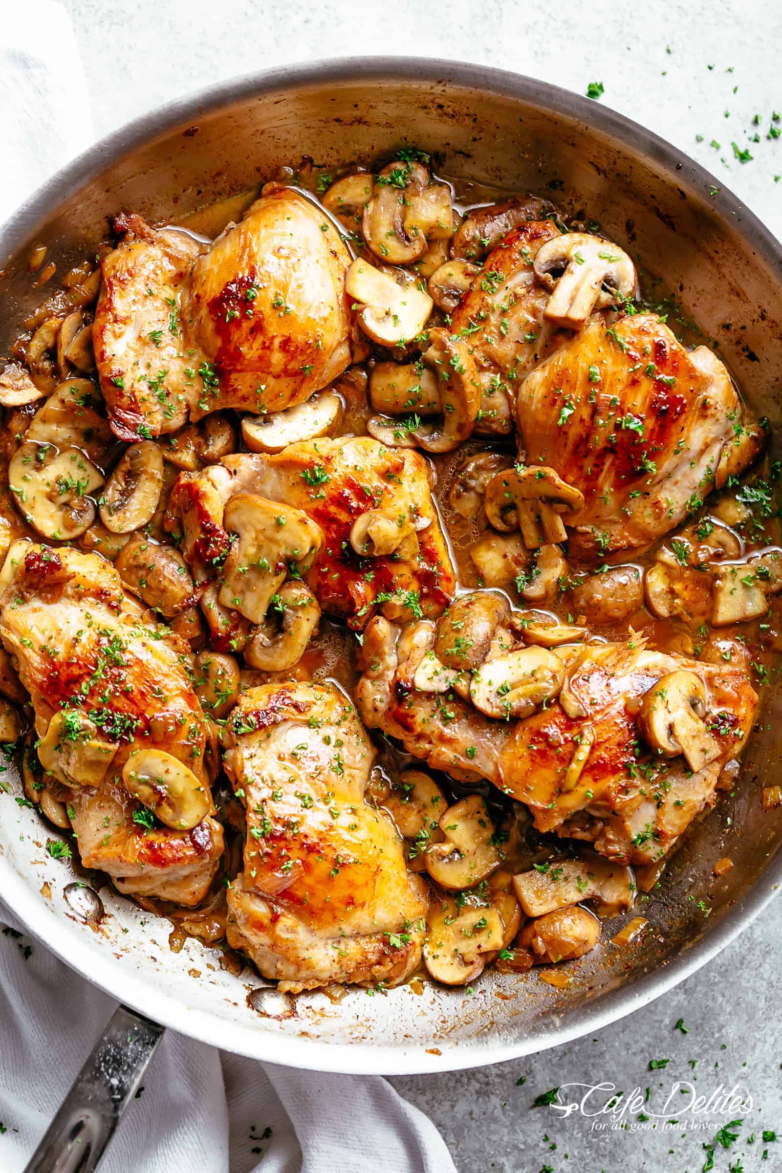 Golden seared chicken thighs in a delicious, buttery garlic mushroom sauce with a sprinkle of herbs is THE weeknight dinner everyone raves about! Serve over rice, pasta, mashed potatoes OR lower carb options like mashed cauliflower or zucchini noodles! | cafedelites.com