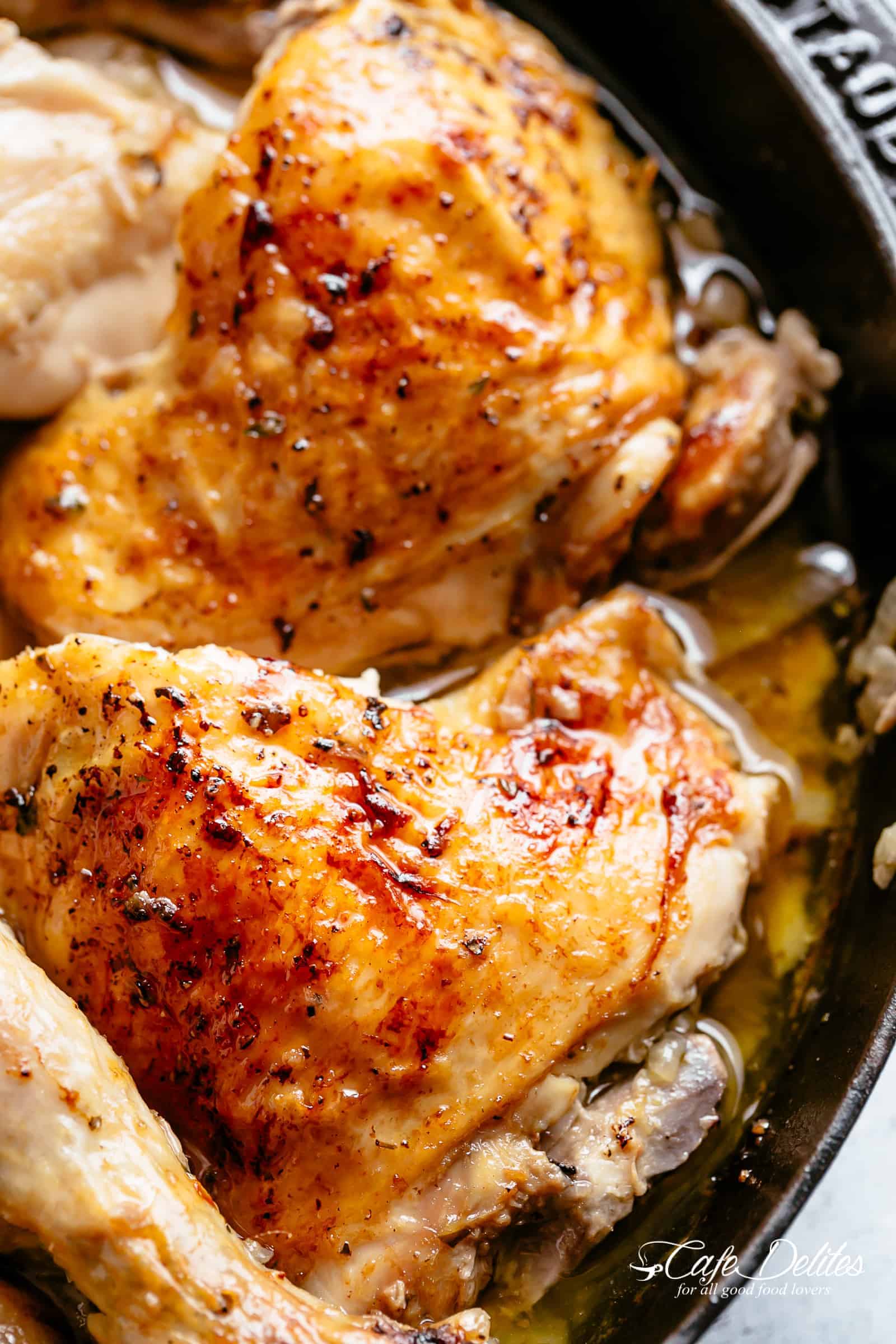 Close up of pieces of roasted chicken in a skillet. 