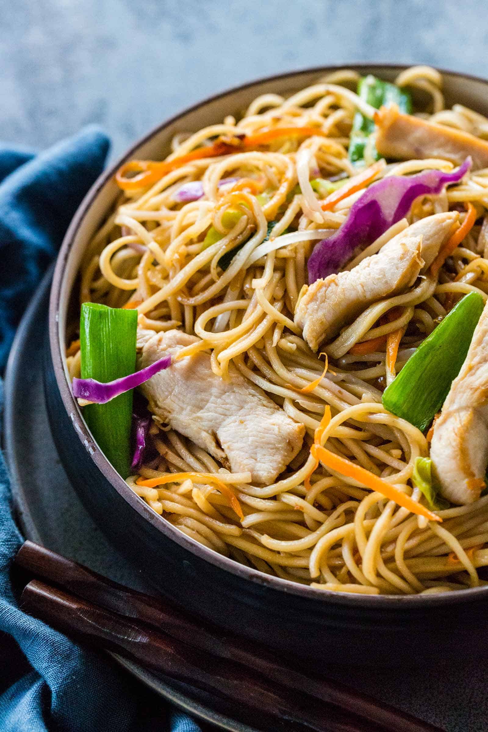 chicken chow mein served in a dark bowl