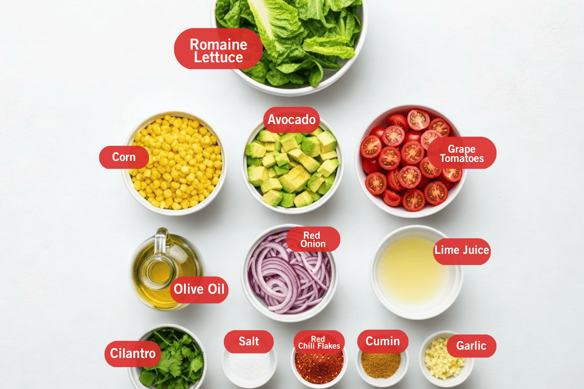 Flat lay photo of ingredient shot of romaine lettuce, corn, avocado, grape tomatoes, olive oil, red onion, lime juice, cilantro, salt, red chili flakes, cumin, garlic