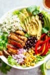 Fajita Chicken Burrito Bowl is packed with juicy golden chicken, cilantro lime rice, avocado and a delicious dressing! Perfect for meal prep! | cafedelites.com