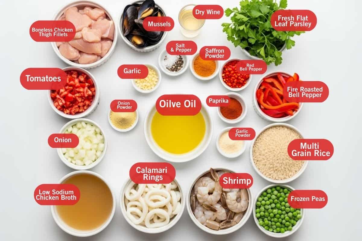 Flat lay photo of ingredient shot of boneless chicken thigh fillets, mussels, dry wine, fresh flat leaf parsley, tomatoes, garlic, salt and pepper, saffron powder, red bell pepper, fire roasted bell pepper. paprika, olive oil, onion powder, onion, low sodium chicken broth, calamari rings, shrimp, garlic powder, multi grain powder, frozen peas