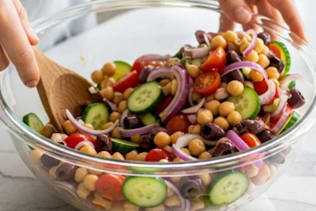 In a large mixing bowl, add the chickpeas, vegetables and kalarta olives and combine.