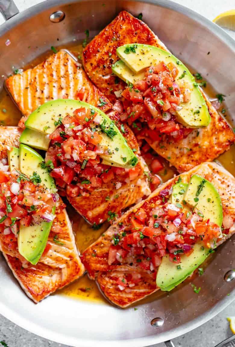 Pan Seared Salmon in a buttery garlic lemon sauce, topped with a fresh tomato salsa and avocado slices! Healthy and low carb! | cafedelites.com