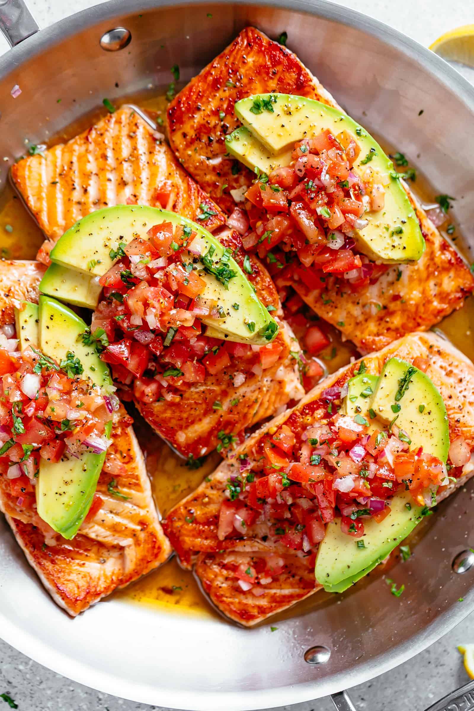 Pan Seared Salmon in a buttery garlic lemon sauce, topped with a fresh tomato salsa and avocado slices! Healthy and low carb! | cafedelites.com