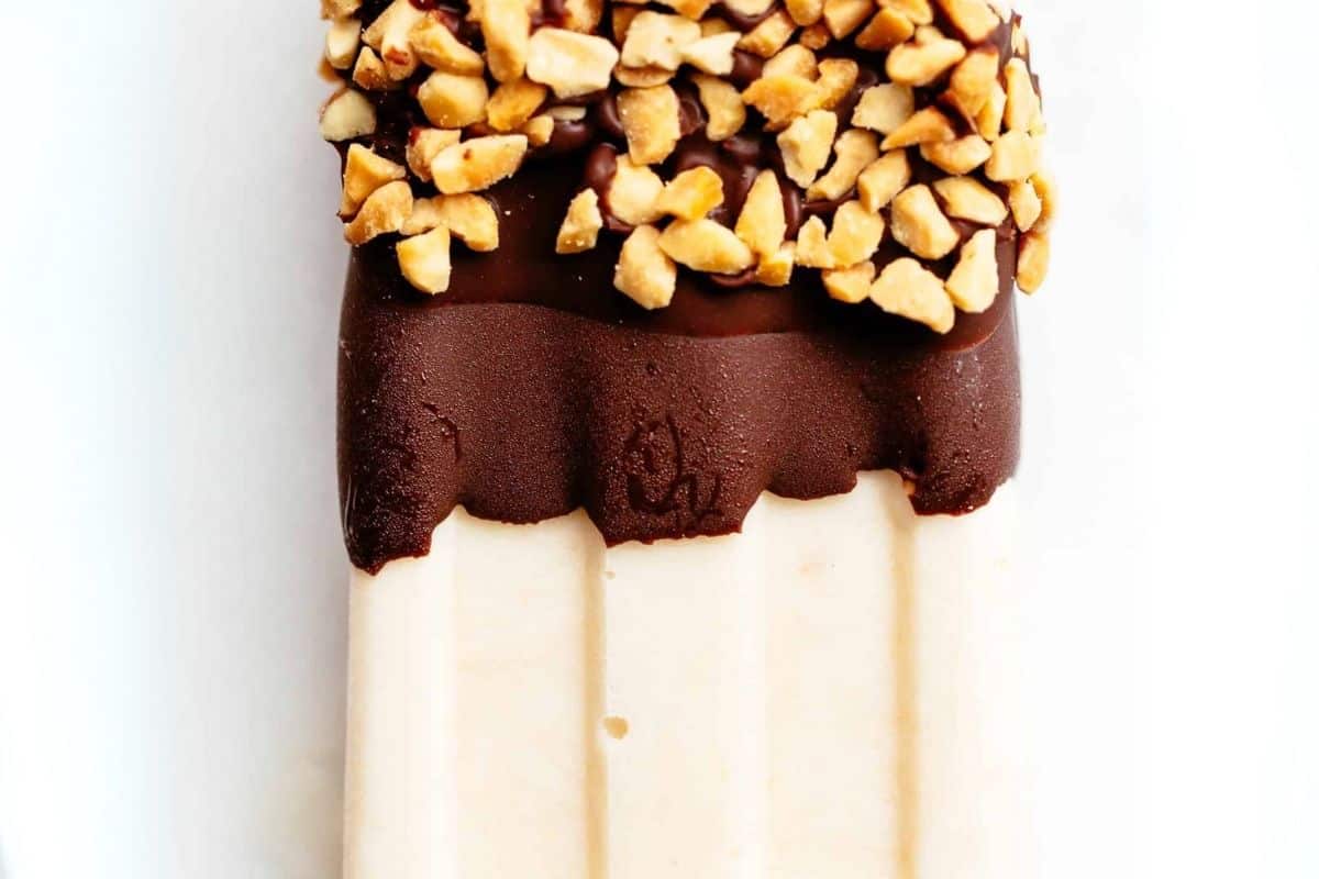 Dip each popsicle into the melted chocolate and sprinkle with crushed peanuts.