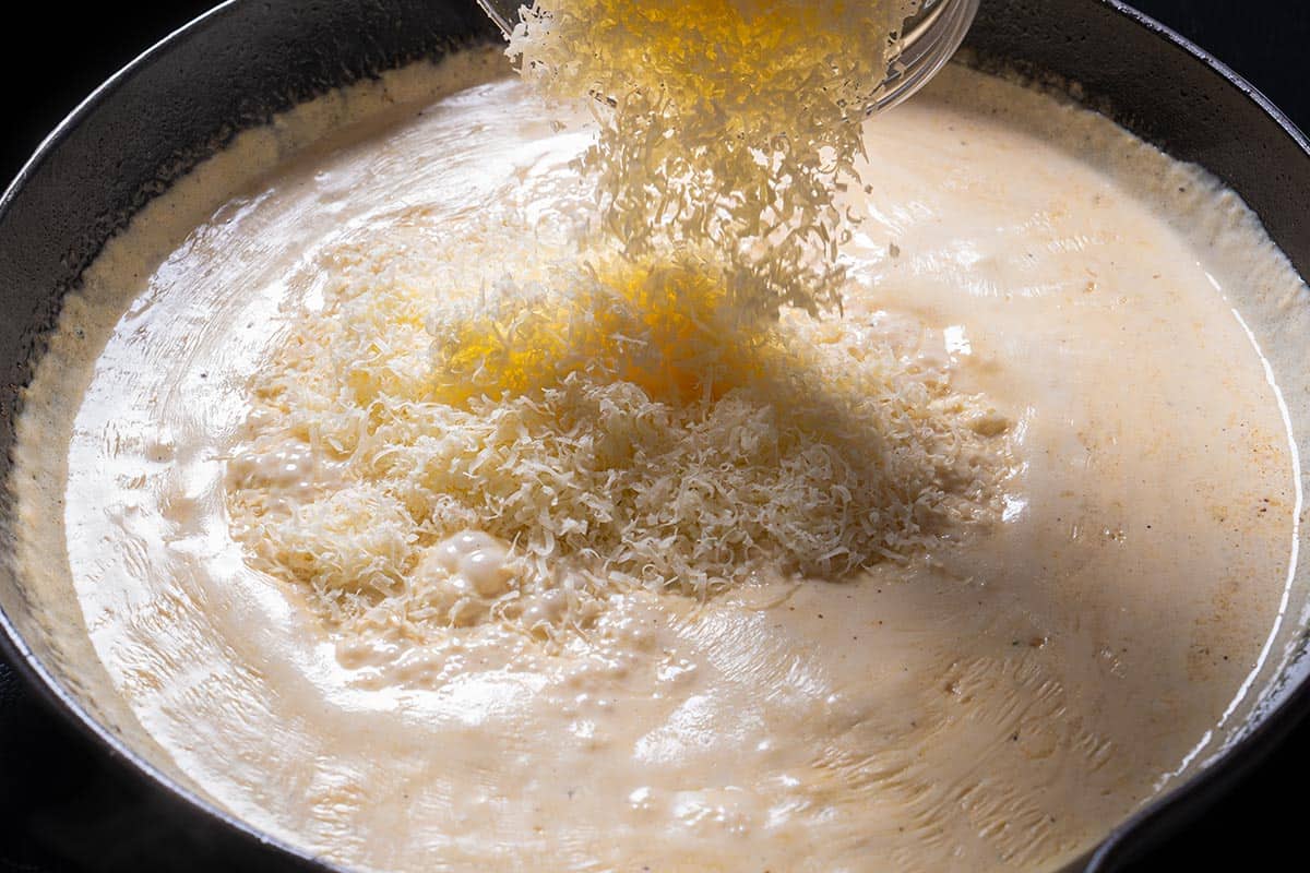 Parmesan is being added to the sauce.