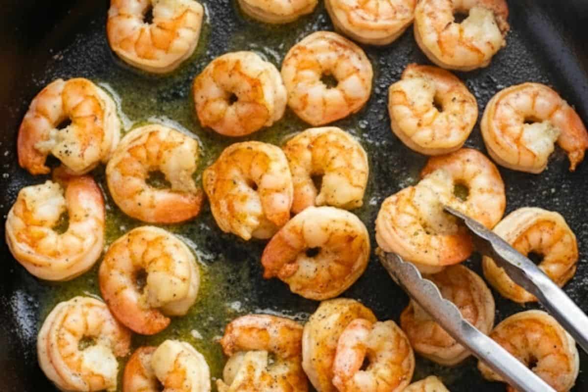 Melt 2 tablespoons butter, season shrimp, and sear until just pink; transfer to a bowl.