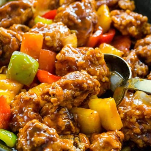 homemade sweet and sour pork cooking in a wok in a bowl