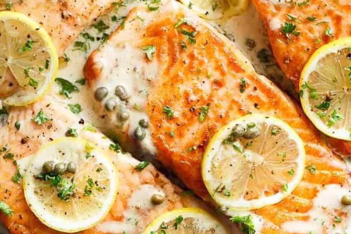 Return the salmon fillets to the pan and coat with sauce. Garnish with parsley, lemon slices.