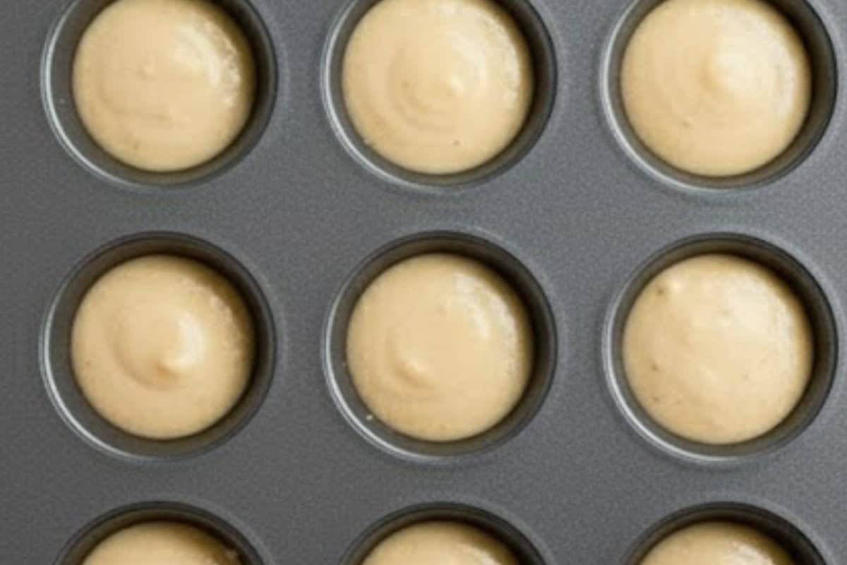 Spoon about 2 teaspoons of batter into each muffin hole, filling them three-quarters.