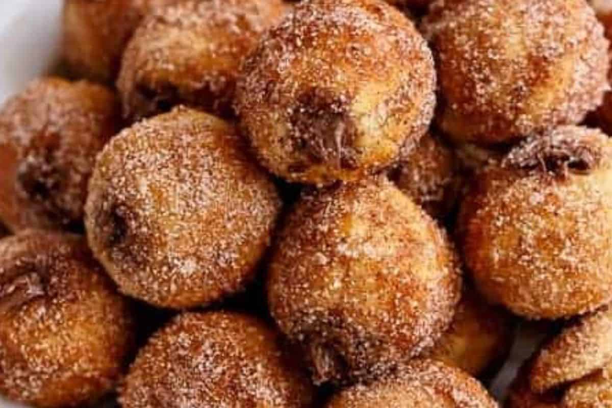 Spoon melted Nutella into a piping bag fitted with a narrow nozzle. and fill each donut.