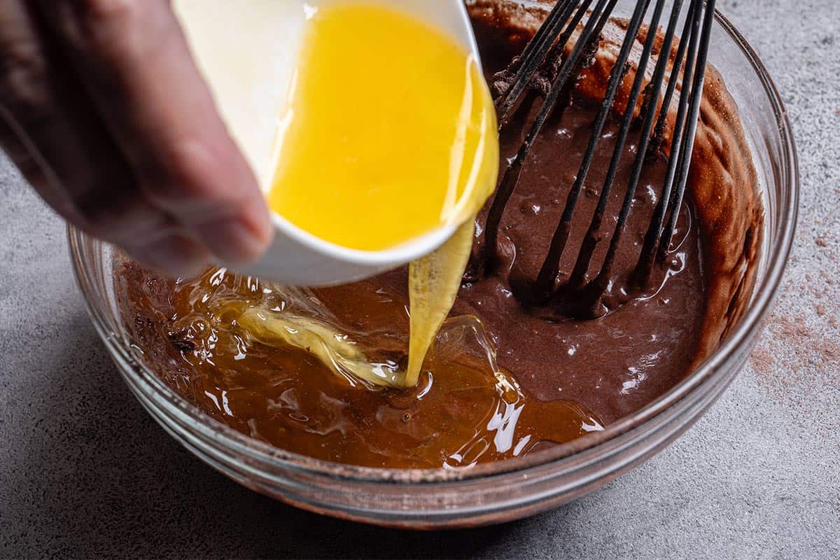 brown chocolate mix with a wisked egg being poured in close up