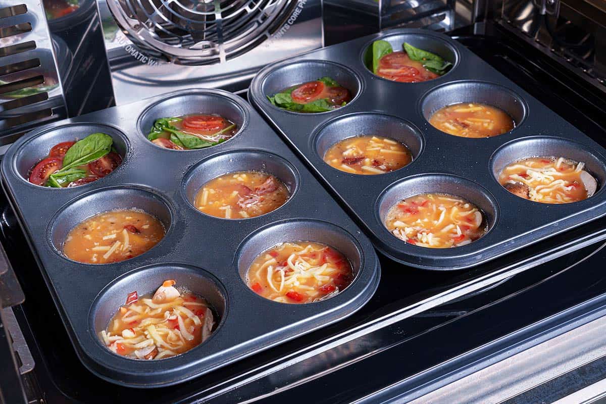 The image shows the muffin tins being placed in the oven to bake for about 15 to 20 minutes, or until set.