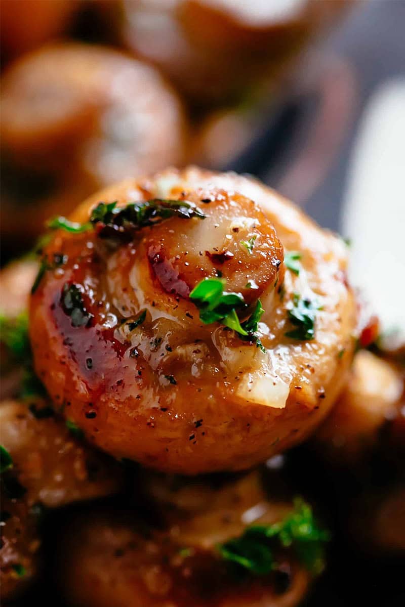 Close-Up image of garlic mushrooms in buttery garlic sauce.