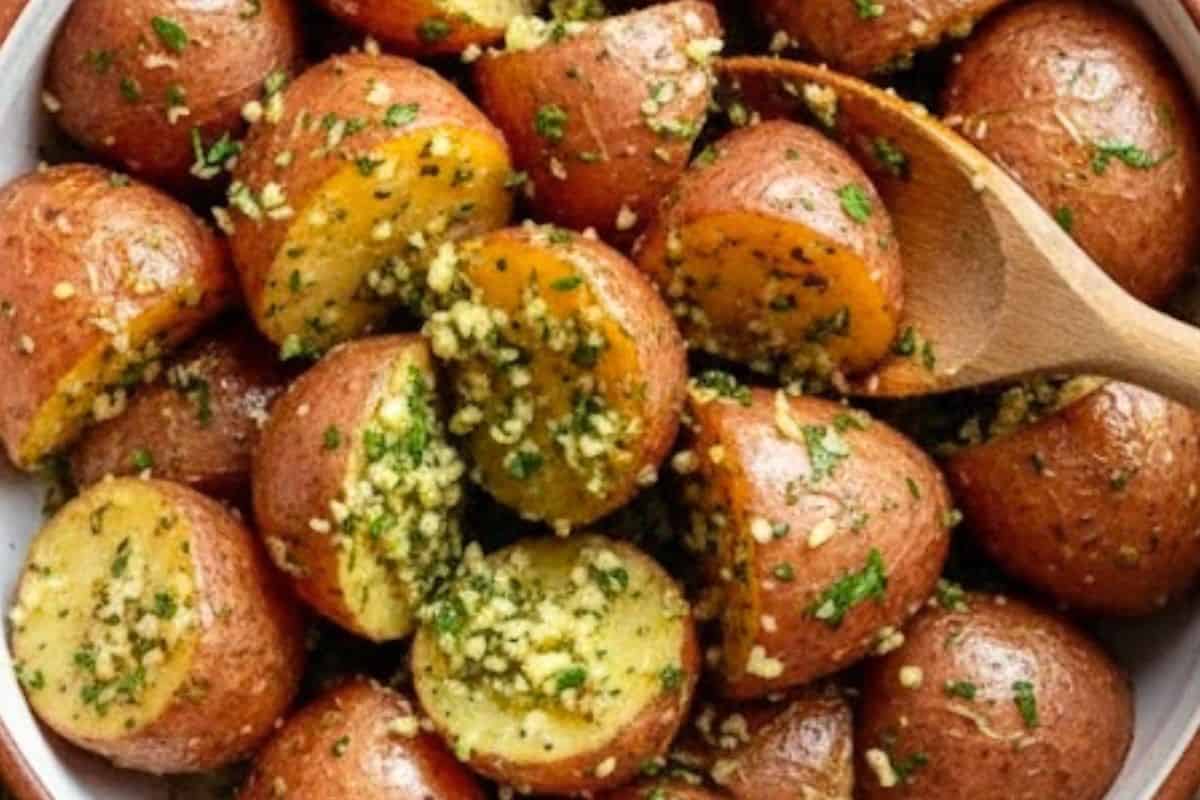 Toss the quartered potatoes into the bowl, making sure each piece is evenly coated with the herby, cheesy mixture.