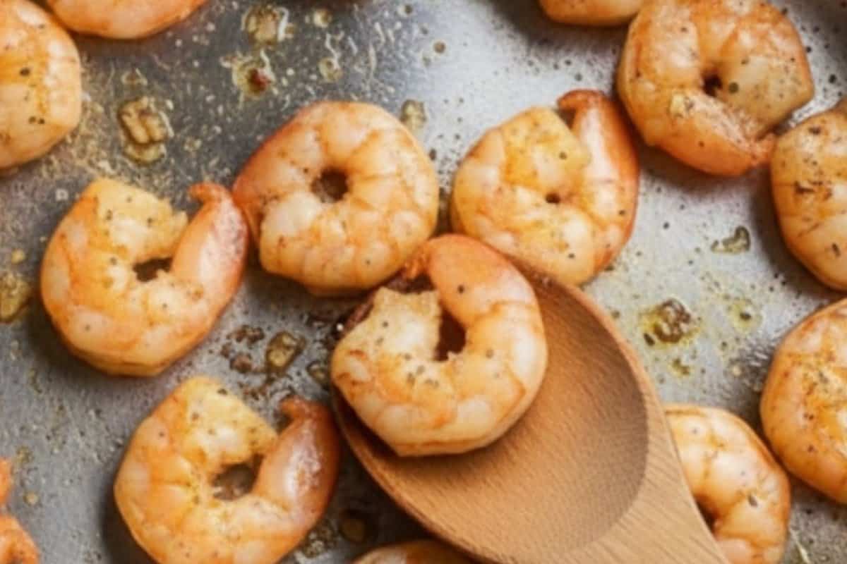 In the same pan, add the remaining tablespoon of oil. Sauté the remaining garlic until fragrant, then add shrimp and cook until they just start to turn pink.