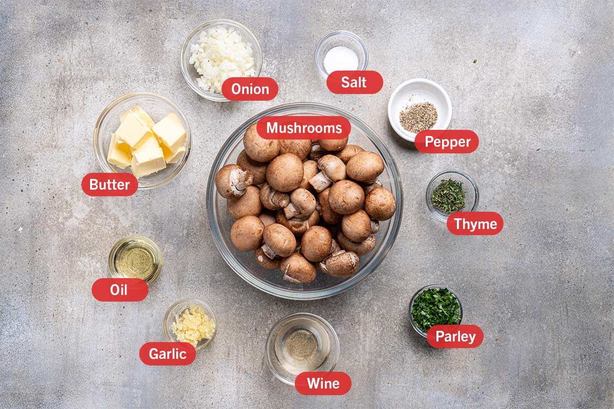 Image of all the needed ingredients for the preparation of this recipe, specifically: mushrooms, thyme, parsley, wine, garlic, oil, butter, onion, salt, and pepper.