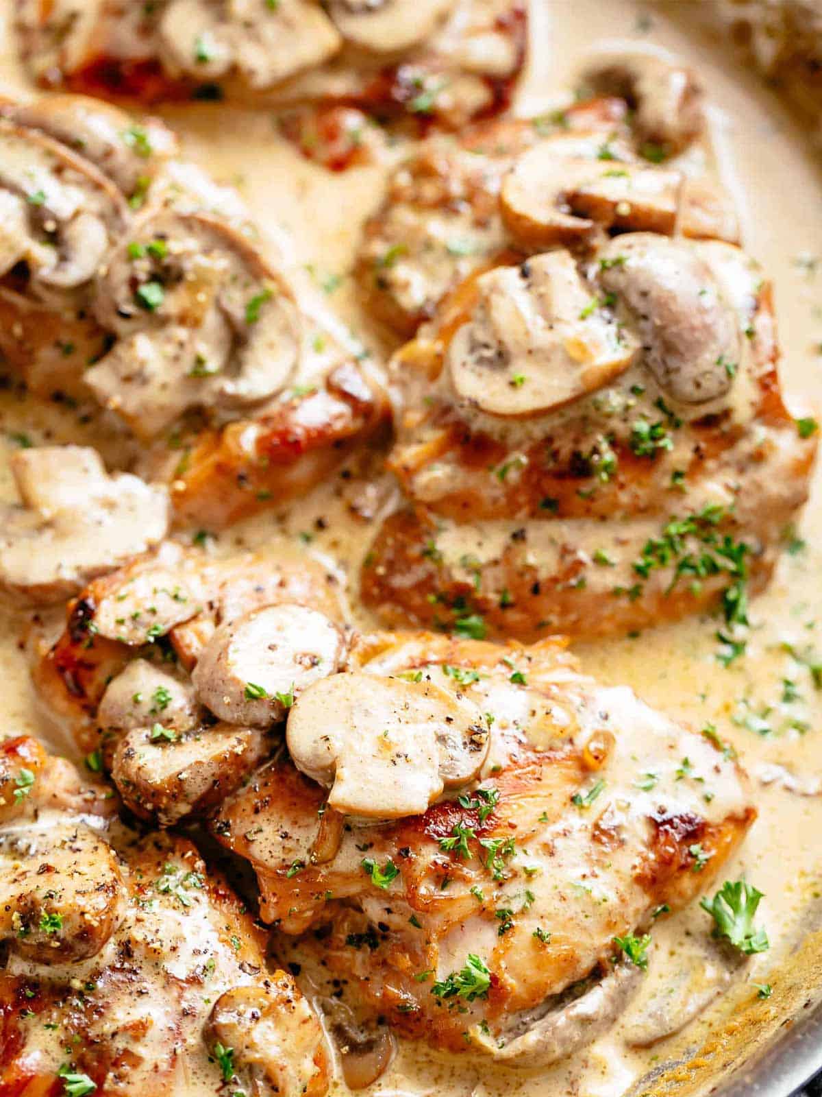 Chicken Thighs With Creamy Mushroom Sauce garnished with parsley in a pan as a close up