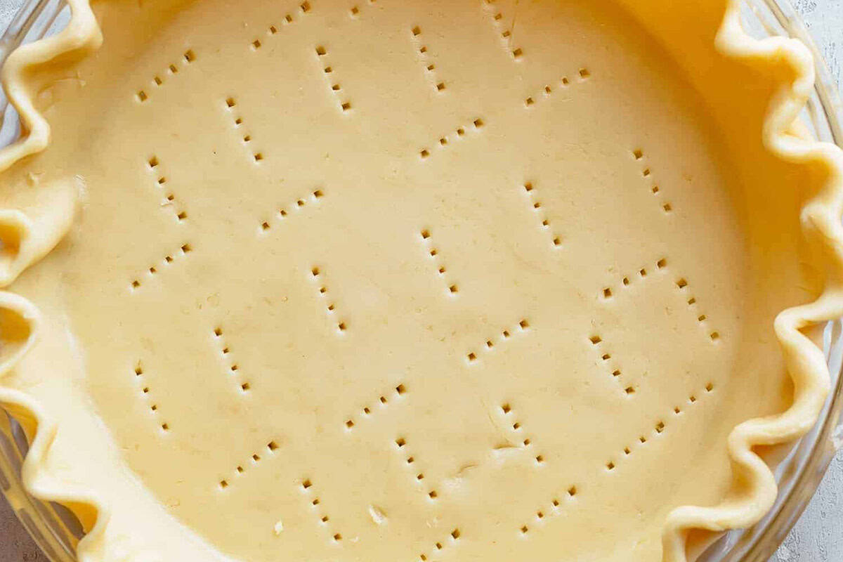 Buttery pie crust on a pie dish.