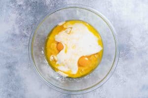 A picture showing buttermilk, honey, and eggs, melted butter in clear bowel in a separate clear mixing bowl.