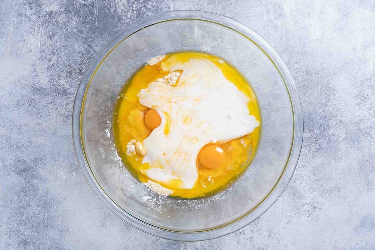 A picture showing buttermilk, honey, and eggs, melted butter in clear bowel in a separate clear mixing bowl.