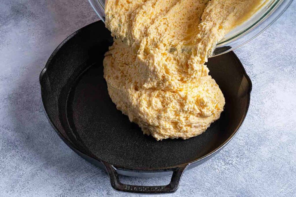 cornbread mixture being poured into pan