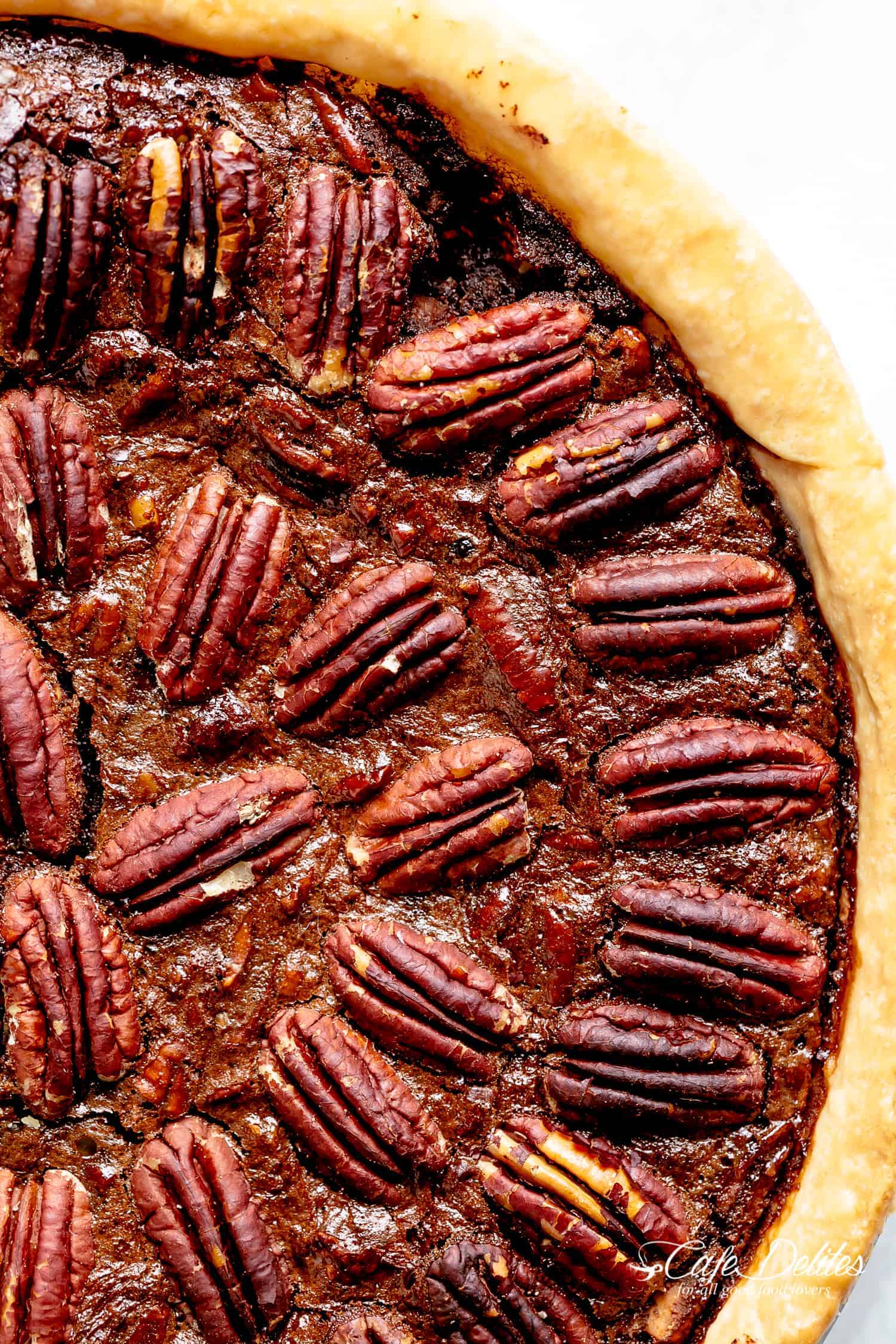 Close up of a completed chocolate pecan pie with a golden crust.