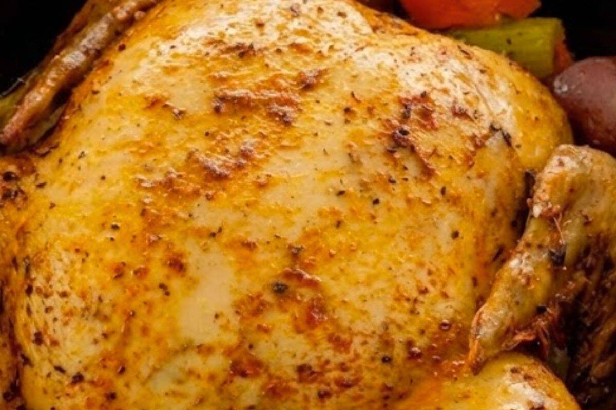 Rub the seasoning paste all over the skin, coating evenly, then place the chicken breast side up on top of the vegetables.