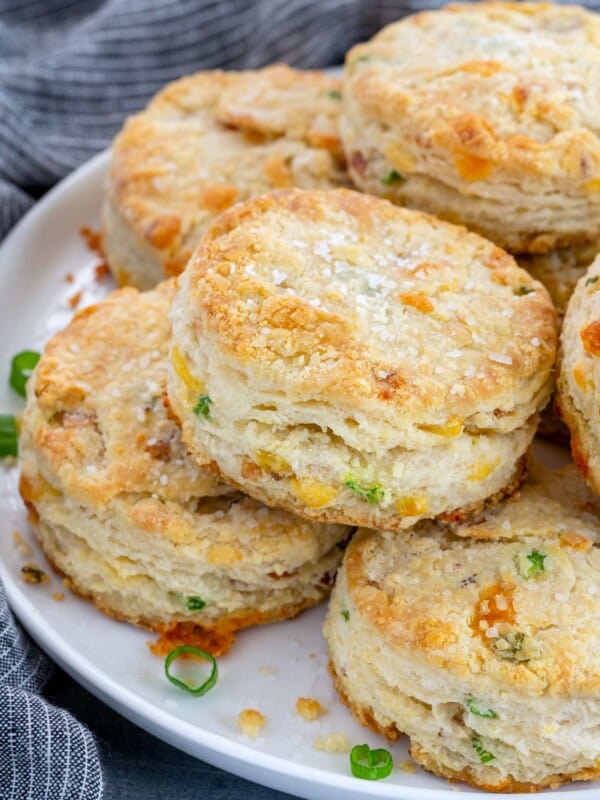 crunchy bacon cheddar biscuits stacked on a white plate