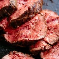 The best, juicy roast Beef Tenderloin slathered with garlic butter that melts in your mouth with every bite! Even better when served with a rich and rustic, easy to make red wine sauce (or jus) | cafedelites.com