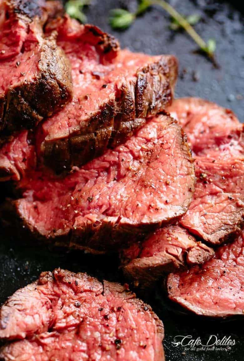The best, juicy roast Beef Tenderloin slathered with garlic butter that melts in your mouth with every bite! Even better when served with a rich and rustic, easy to make red wine sauce (or jus) | cafedelites.com