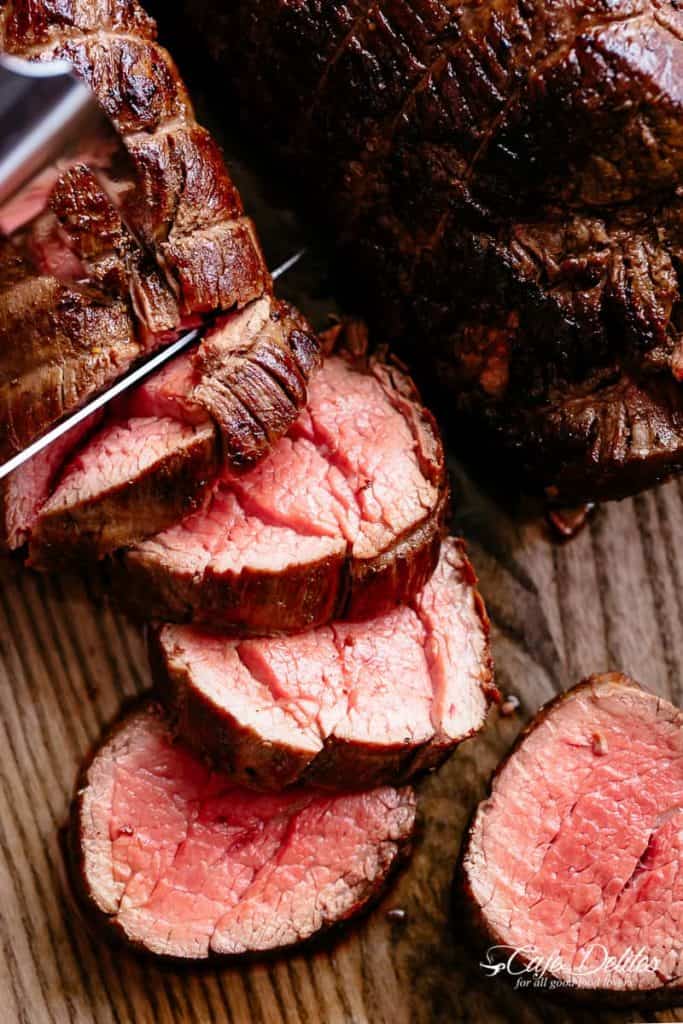 The best, juicy roast Beef Tenderloin slathered with garlic butter that melts in your mouth with every bite! Even better when served with a rich and rustic, easy to make red wine sauce (or jus) | cafedelites.com