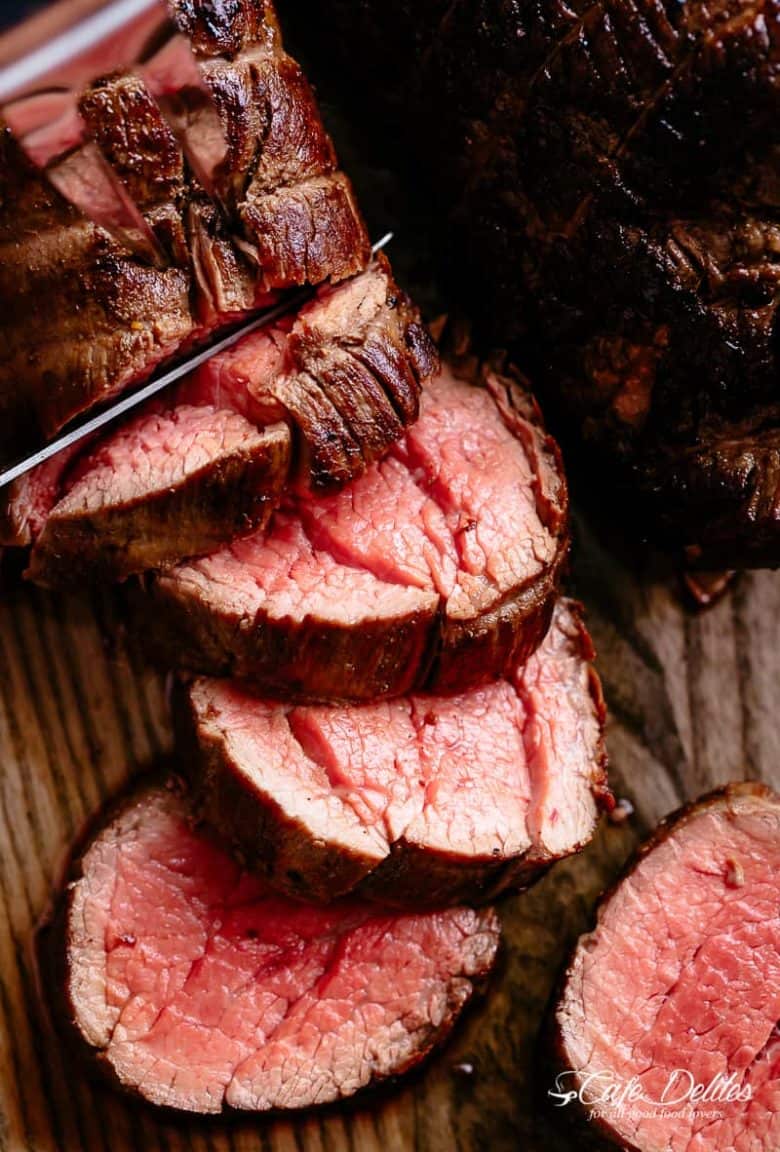 The best, juicy roast Beef Tenderloin slathered with garlic butter that melts in your mouth with every bite! Even better when served with a rich and rustic, easy to make red wine sauce (or jus) | cafedelites.com