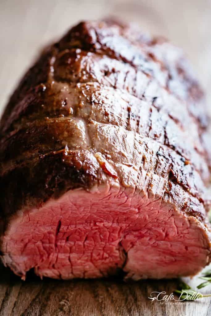 Close up of juicy roast beef tenderloin roasted and cut to see the pink medium rare inside.