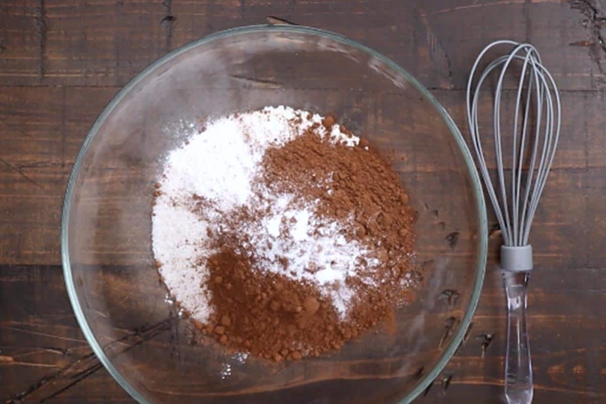 Mixing the sugar, cocoa powder, baking powder, and salt in a bowl.