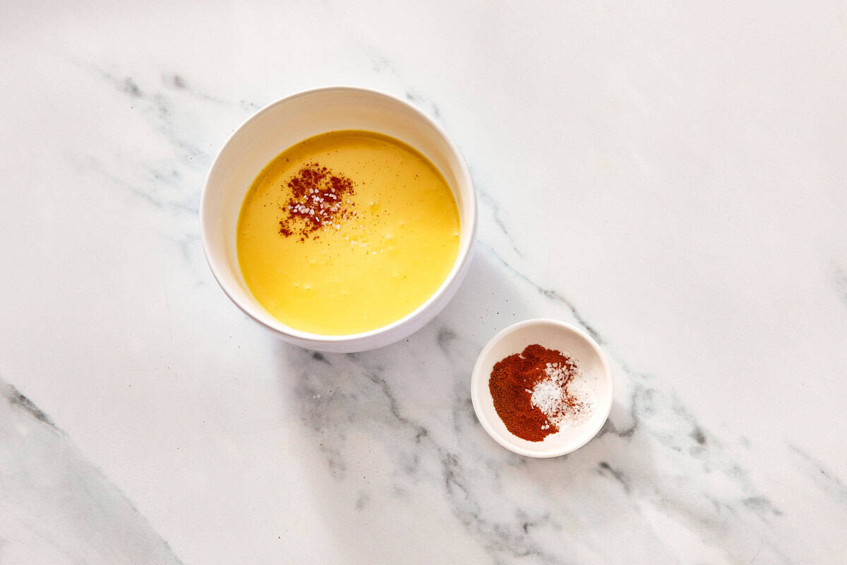 Finished Hollandaise sauce in a small bowl.