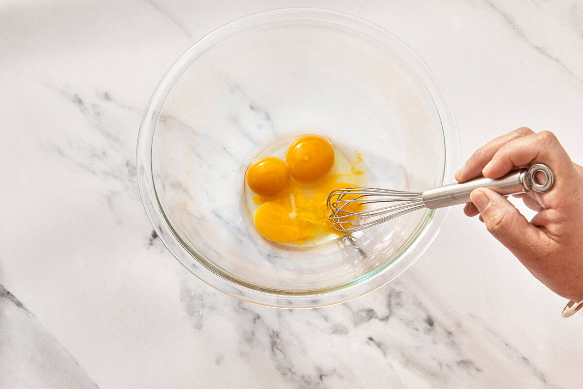 Egg yolks and fresh lemon juice in a clear glass jug.