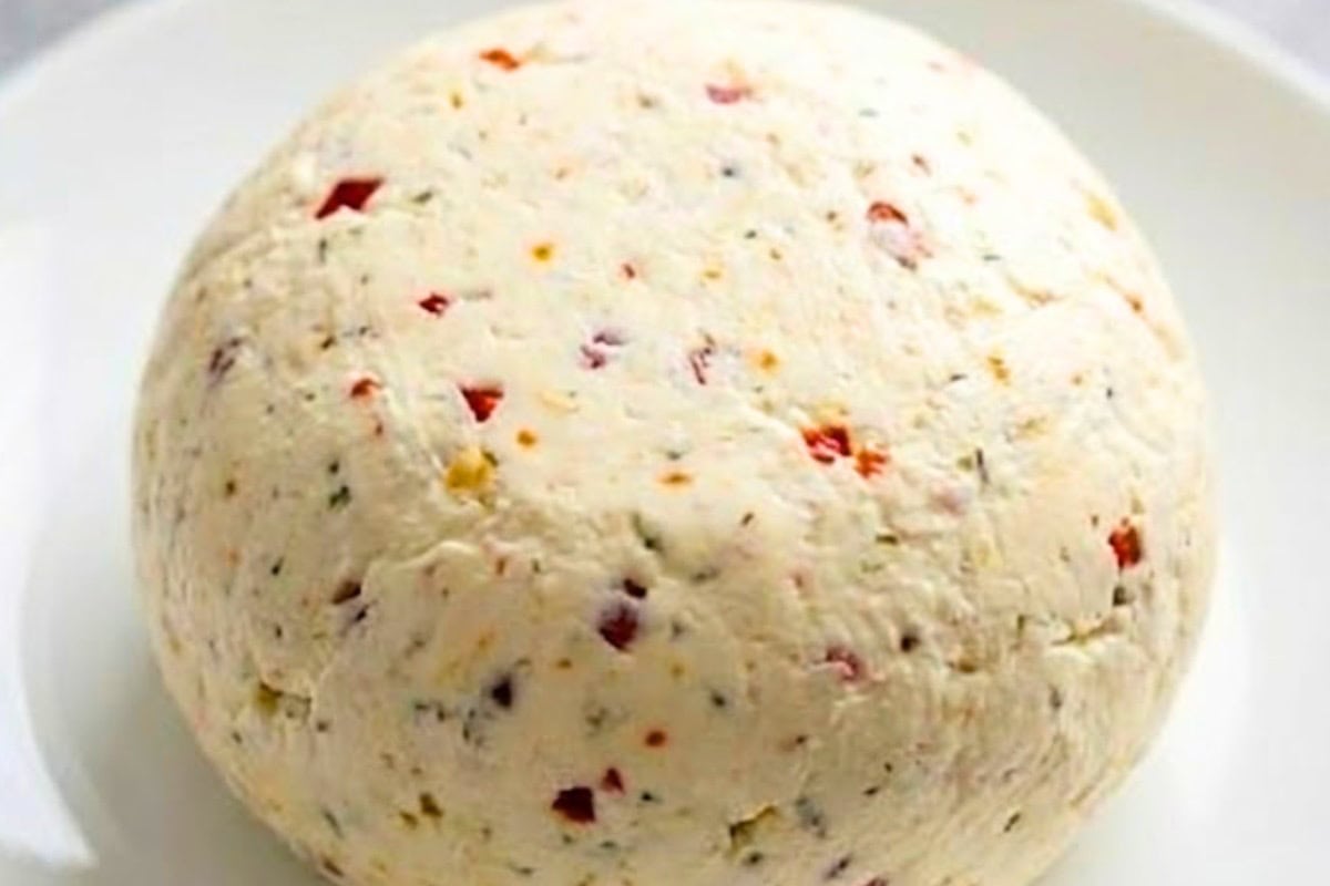 Using your hands, mould the wrapped mixture into a ball. Peel away the bottom layer of plastic wrap and place the cheese ball onto a serving plate. - 5