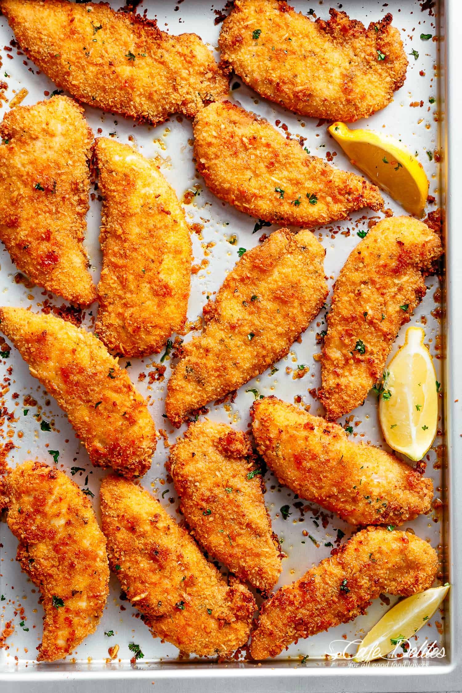 Chicken Tenders on a baking pan with garlic, lemon and parmesan breading | cafedelites.com