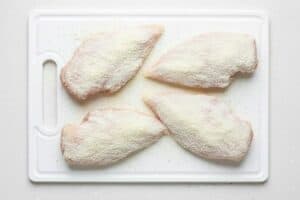In a shallow bowl, combine the flour and Parmesan cheese and set it aside. Coat the seasoned chicken well in this mixture.