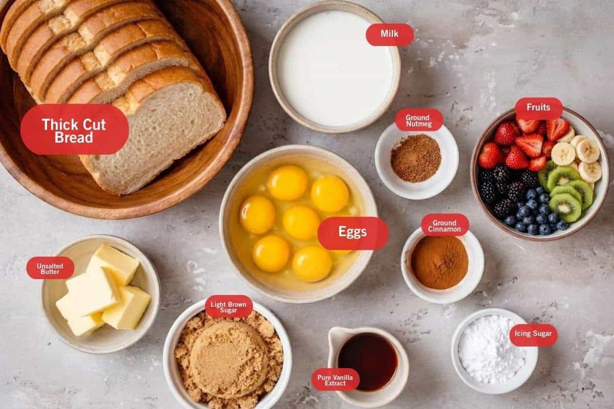 Flay lay photo of ingredient shot of thick cut bread, milk, ground nutmeg, fruits, ground cinnamon, icing sugar, pure vanilla eggs, light brown sugar