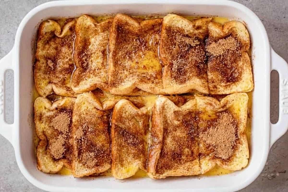 Arrange half the bread over the sugar base, pour over half the custard, then sprinkle with half the spiced sugar.